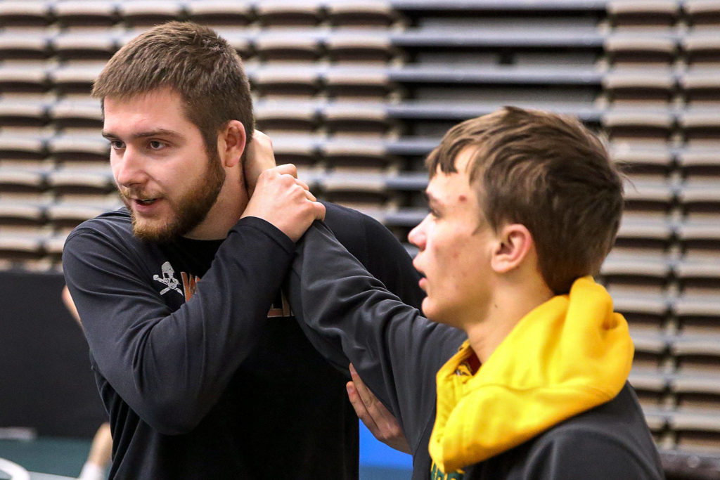 Darrington assistant coach Mason McKenzie (left) works with Nik Requa (right) during practice Feb. 6 at Darrington High School. (Kevin Clark / The Herald)
