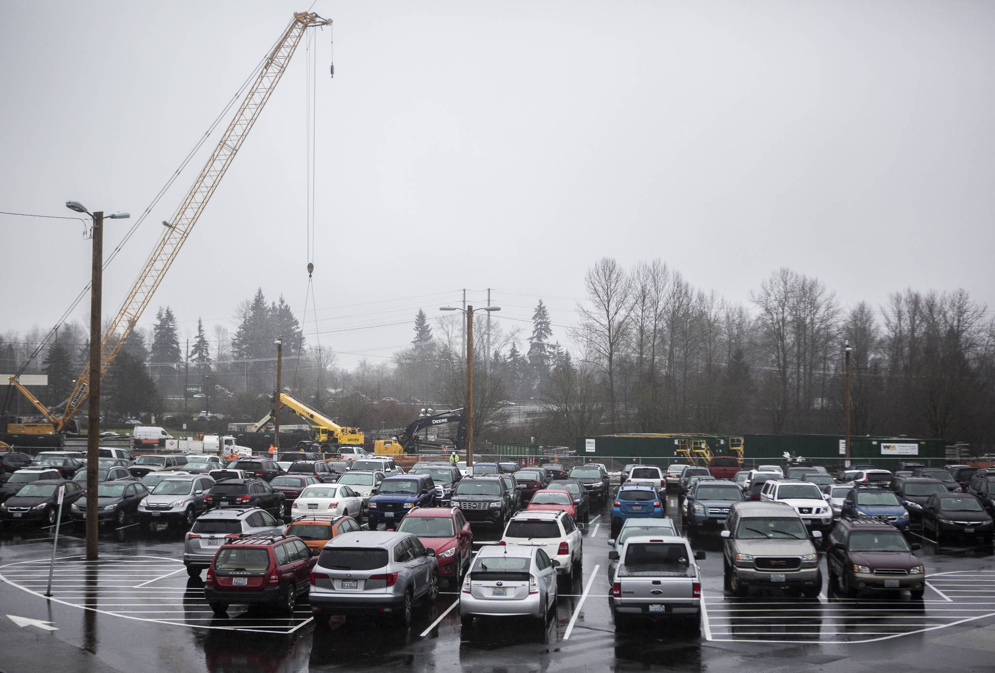 Construction continues behind a full Lynnwood Transit Center parking lot Wednesday in Lynnwood. Parking spaces will shift throughout the year to make room for work on the light rail station. (Olivia Vanni / The Herald)