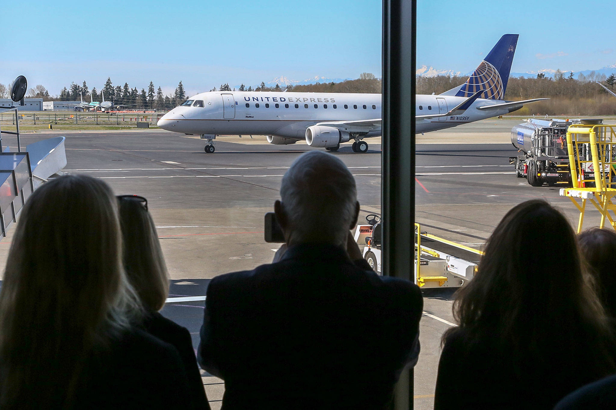 The first United Airlines flight serving Paine Field in Everett taxis to the gate last March 31. (Kevin Clark / The Herald)