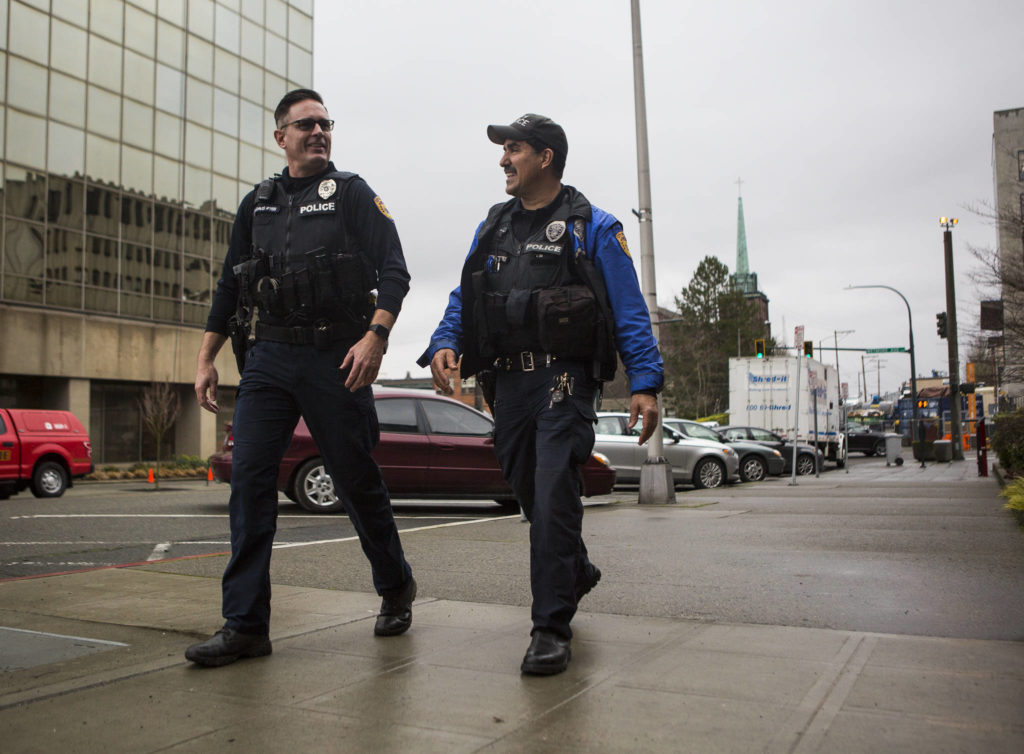 Everett Police Officers Kevin Davis (left) and Mike Bernardi stroll through downtown Thursday. (Olivia Vanni / The Herald)
