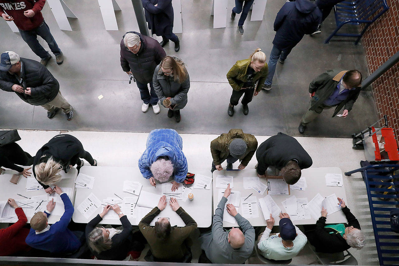 Caucus goers check in at a caucus at Roosevelt Hight School on Monday in Des Moines, Iowa. (AP Photo/Andrew Harnik)
