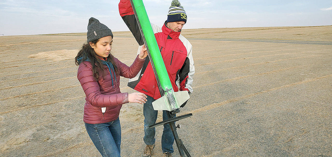 Trixie Teng, past president of Edmonds Community College’s rocketry society, readies her rocket for launch with Will Hamp, Edmonds Community College engineering faculty and club adviser. (Edmonds Community College)