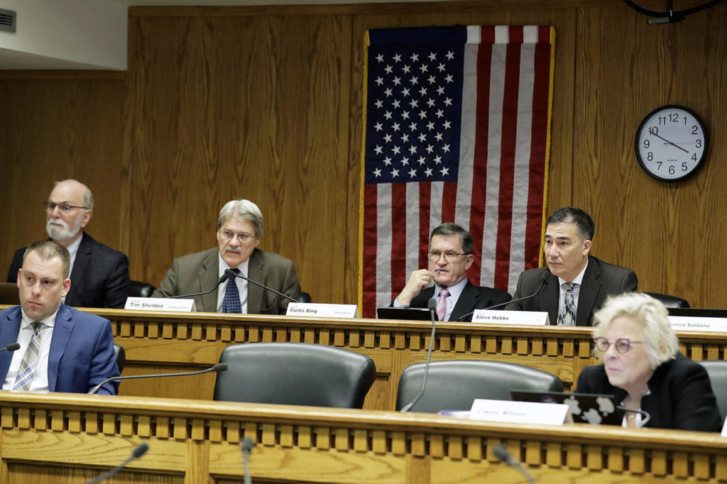 Members of the Washington State Senate Transportation Committee, including chairman Sen. Steve Hobbs, D-Lake Stevens (upper right), listen Feb. 4 during a hearing at the Capitol in Olympia regarding proposed legislation surrounding I-976, an initiative passed by voters that would cut car tab registration fees to $30. (AP Photo/Ted S. Warren)
