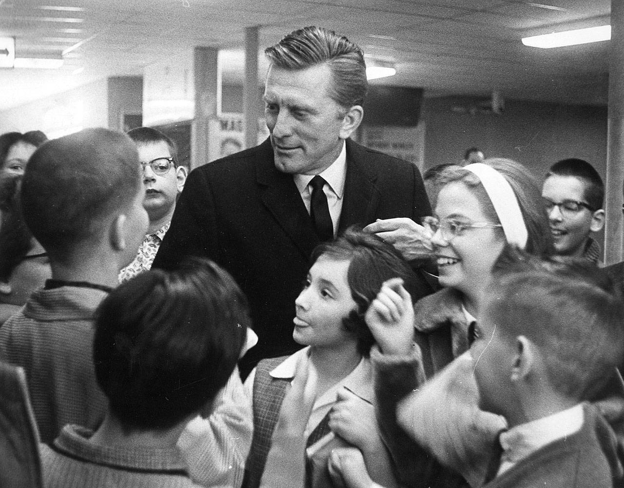 Kirk Douglas is surrounded by young fans at National Airport in Arlington, Virginia, in January 1963. He died Wednesday at the age of 103. (Vic Casamento / The Washington Post)