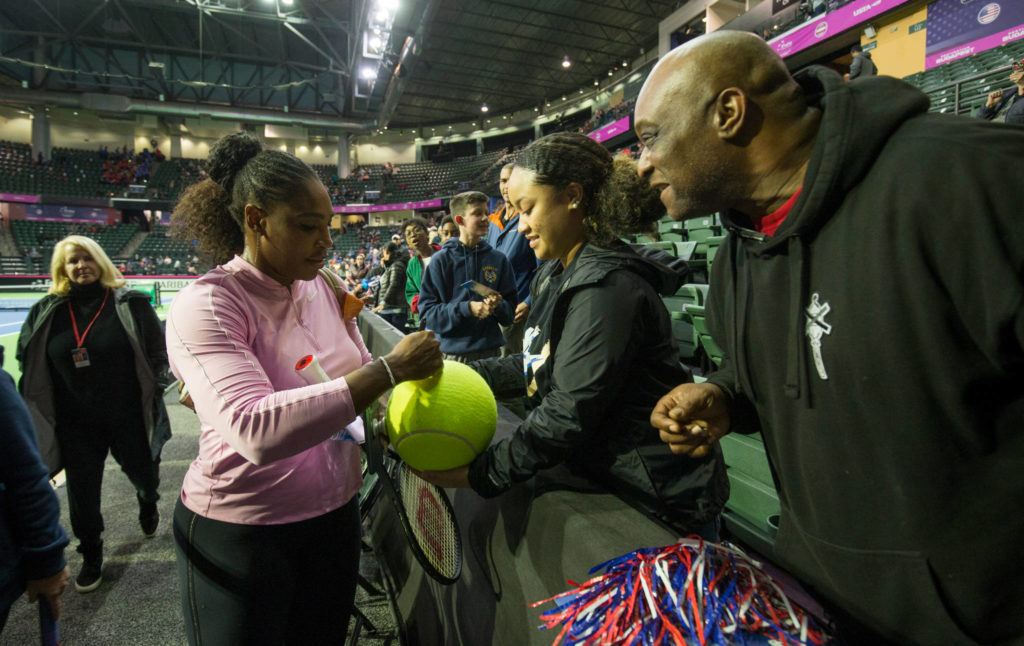 Serena Williams signs a tennis ball for Anissa Blake and her father, Angelo, of Marysville, before the start of the FedCup qualifying rounds at Angel of the Winds Arena on Friday in Everett. (Andy Bronson / The Herald)
