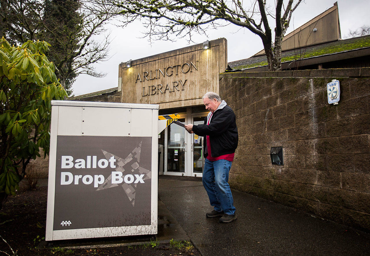 Kevin Duncan puts his ballot in the ballot drop box outside of the Arlington Library on Tuesday in Arlington The Arlington school District had three measures on the February ballot, including one to replace Post Middle School. (Olivia Vanni / The Herald)