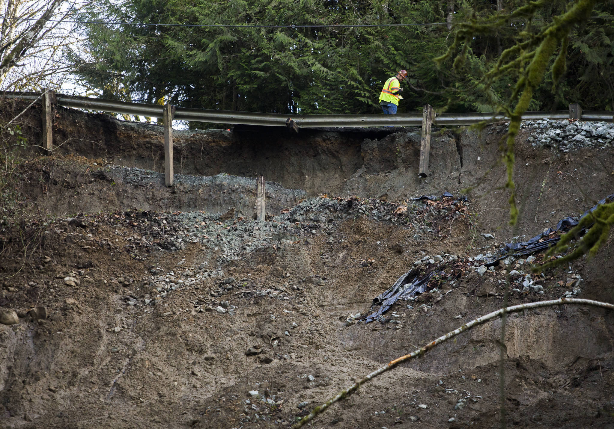 A Geotechnical Testing & Inspections worker surveys the slide site off of Ben Howard Road on Monday in Monroe. (Olivia Vanni / The Herald)