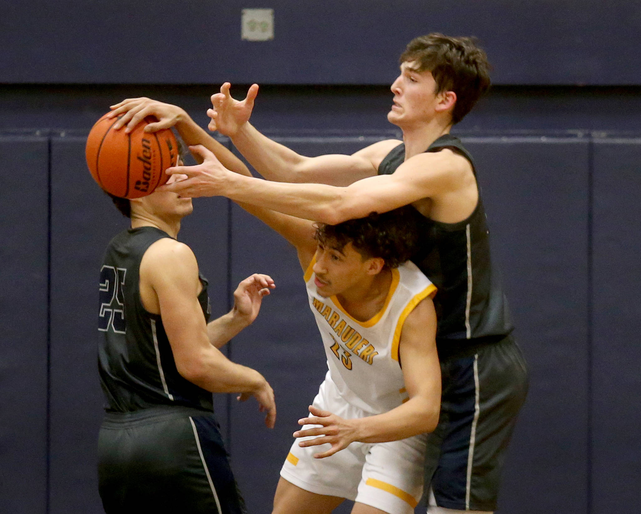 Glacier Peak’s Pierce Darlington reaches over Mariner’s Tony MacArthur to grab a loose ball during a Wesco 4A boys basketball game Tuesday at Mariner High School in Everett. Darlington and the Grizzlies beat MacArthur and the Marauders 90-87 in double overtime to take a perfect 20-0 record into the postseason. Mariner finished the regular season at 16-4. (Andy Bronson / The Herald)