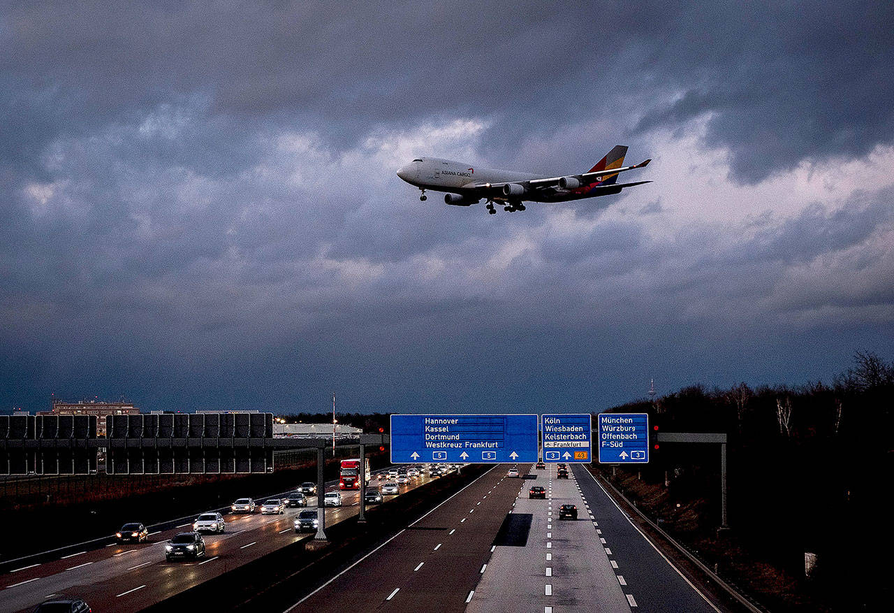 A Boeing 747 approaches the international airport flying over a highway in stormy weather in Frankfurt, Germany, on Tuesday. (AP Photo/Michael Probst)