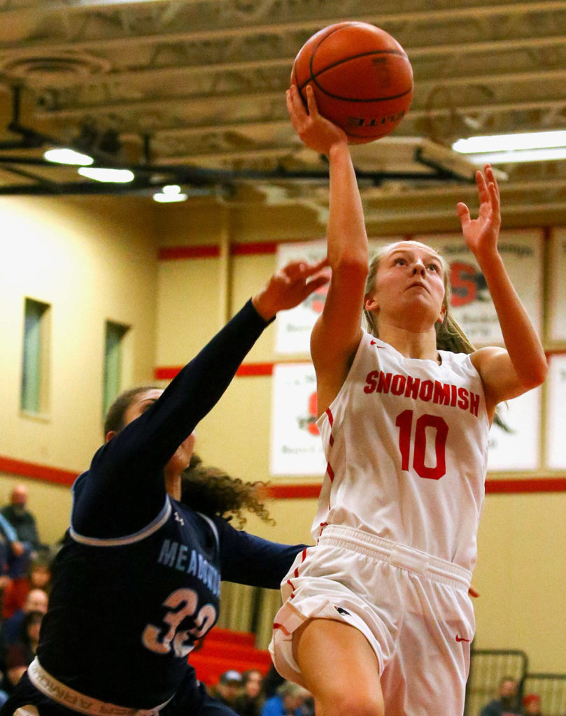 Snohomish junior guard Kayla Soderstrom (10) drives in for a layup with Meadowdale senior Soriah Swinton trailing during a 3A Northwest District Tournament game Friday night at Snohomish High School. The Panthers won 57-39. (Kevin Clark / The Herald)
