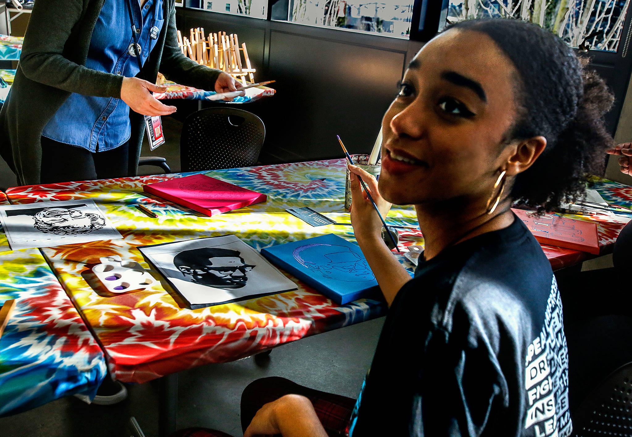 Nyannah Jackson, 19, paints a miniature canvas with the image of Malcolm X as part of a Black History Month event at Everett Community College Wednesday. (Dan Bates / The Herald)