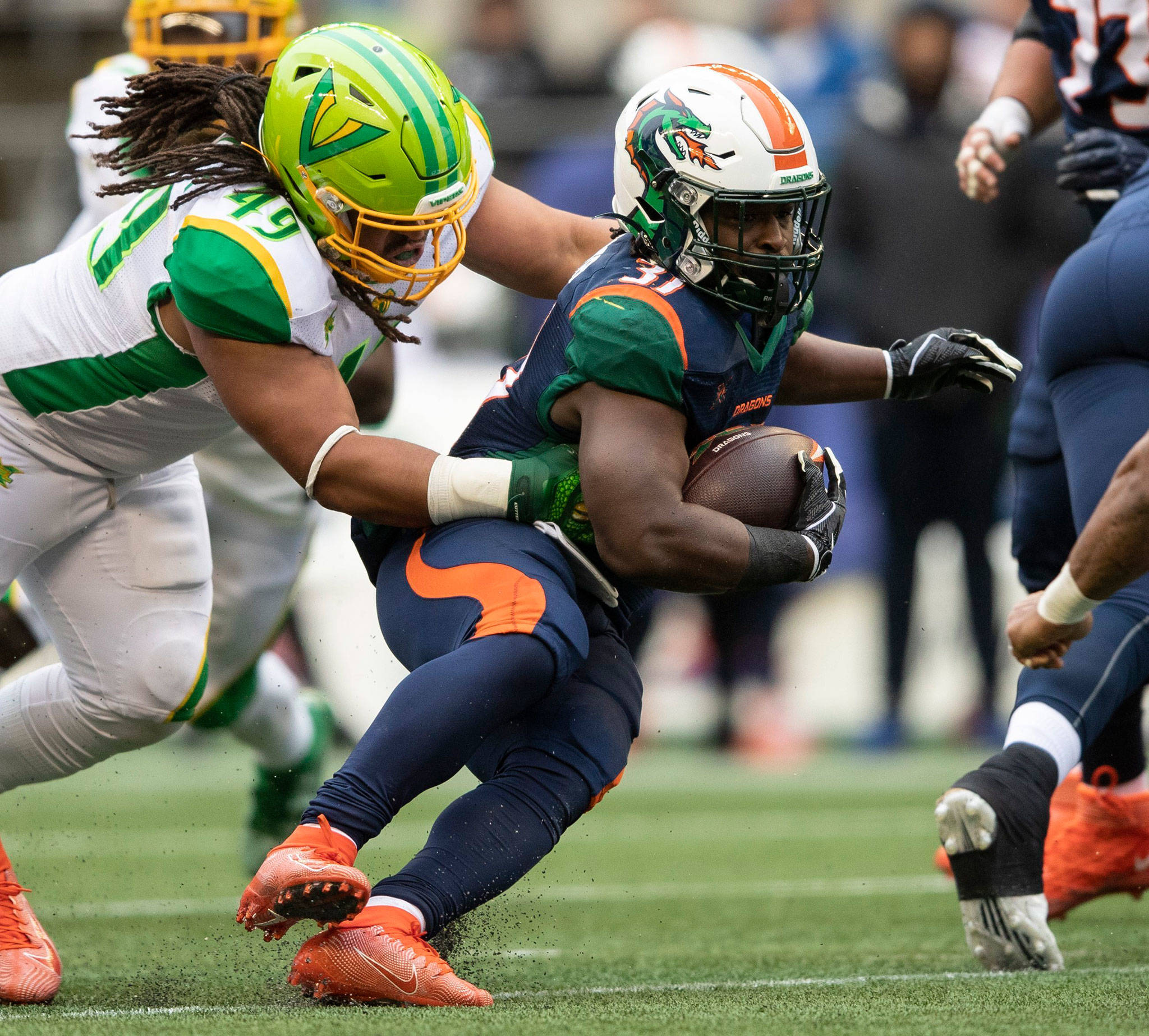 Dragons running back Ja’Quan Gardner (right) carries the ball as the Vipers’ Nikita Whitlock attempts a tackle during an XFL game Saturday, in Seattle. (Amanda Snyder / The Seattle Times via AP)