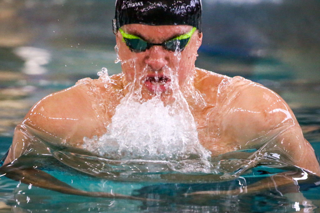 Lake Stevens’ Alejandro Flores competes in the 100-yard breaststroke during the 4A Northwest District swim and dive finals Saturday at Snohomish Aquatic Center in Snohomish. (Kevin Clark / The Herald)
