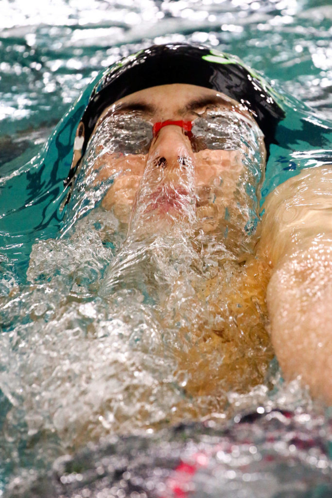 Jackson’s Alex Georgiev competes in the 100-yard backstroke during the 4A Northwest District swim and dive finals Saturday at Snohomish Aquatic Center in Snohomish. (Kevin Clark / The Herald)
