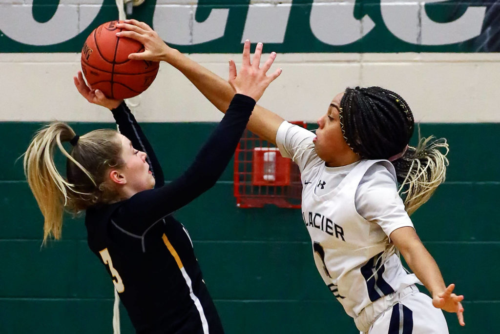Glacier Peak’s Aaliyah Collins (right) blocks the shot of Inglemoor’s Lucy Young during a playoff game Tuesday at Jackson High School in Mill Creek. (Kevin Clark / The Herald)
