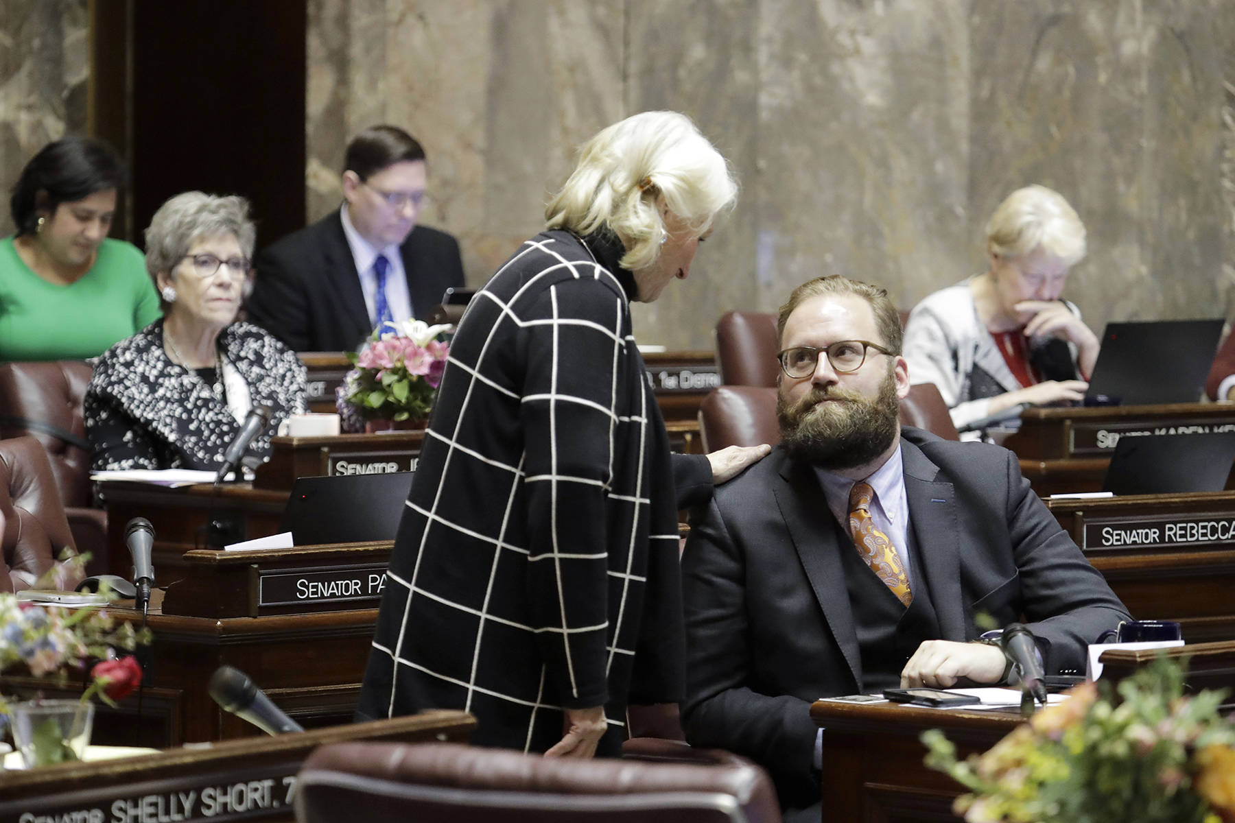 Sen. Marko Liias, D-Lynnwood (right) talks with Sen. Randi Becker, R-Eatonville (center) on the Senate floor Wednesday at the Capitol in Olympia. Lawmakers were busy throughout the day, as Wednesday was the floor cutoff deadline for the 2020 legislative session. (AP Photo/Ted S. Warren)