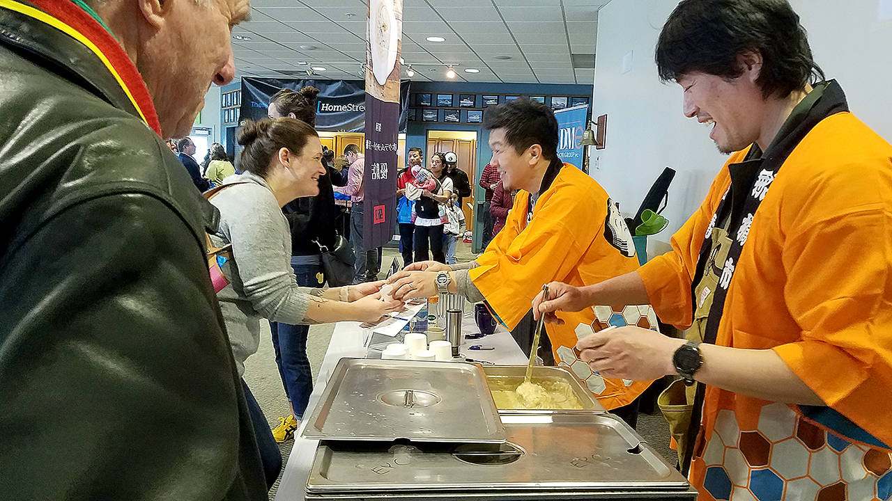 Japanese chef Yuji Kurokawa (right) whose chowder won contests in Japan, offers samples at Edmonds’ annual chowder cook-off Saturday. (Sharon Salyer / The Herald)