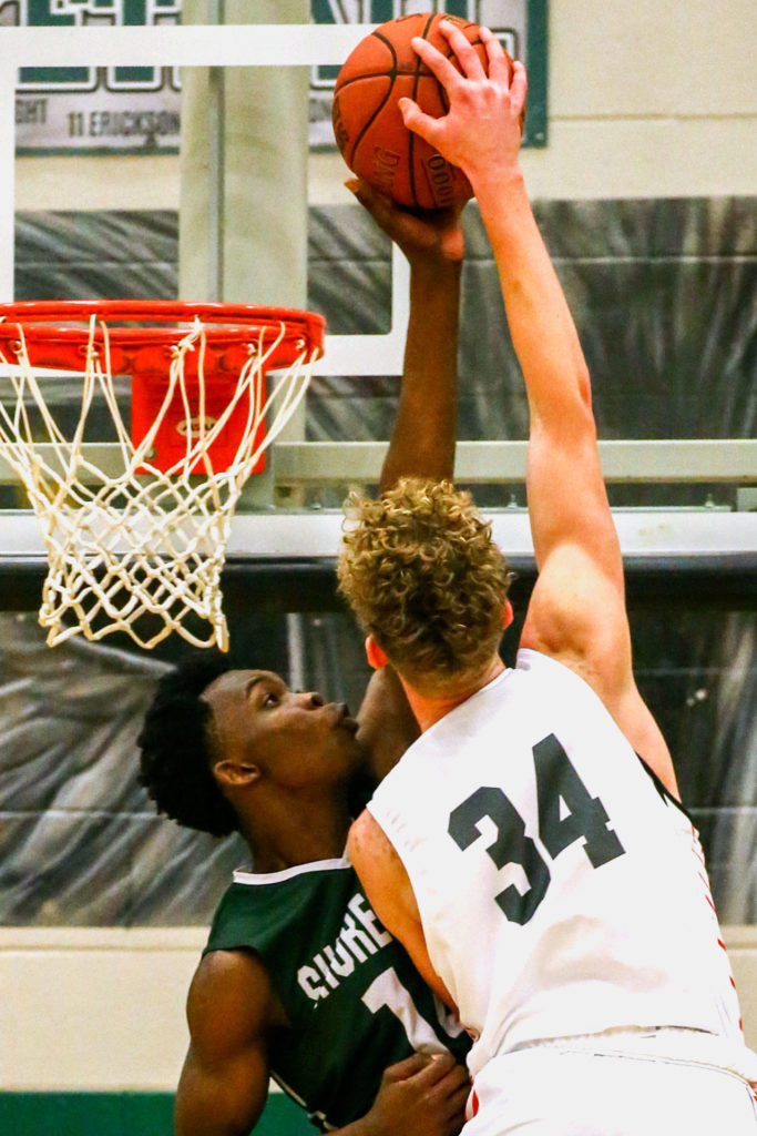 Shorecrest’s Tim Opany blocks a dunk attempt by Stanwood’s Kaeden McGlothin during a Northwest District Tournament semifinal Wednesday evening at Jackson High School in Mill Creek. Shorecrest beat Stanwood 68-58. (Kevin Clark / The Herald)
