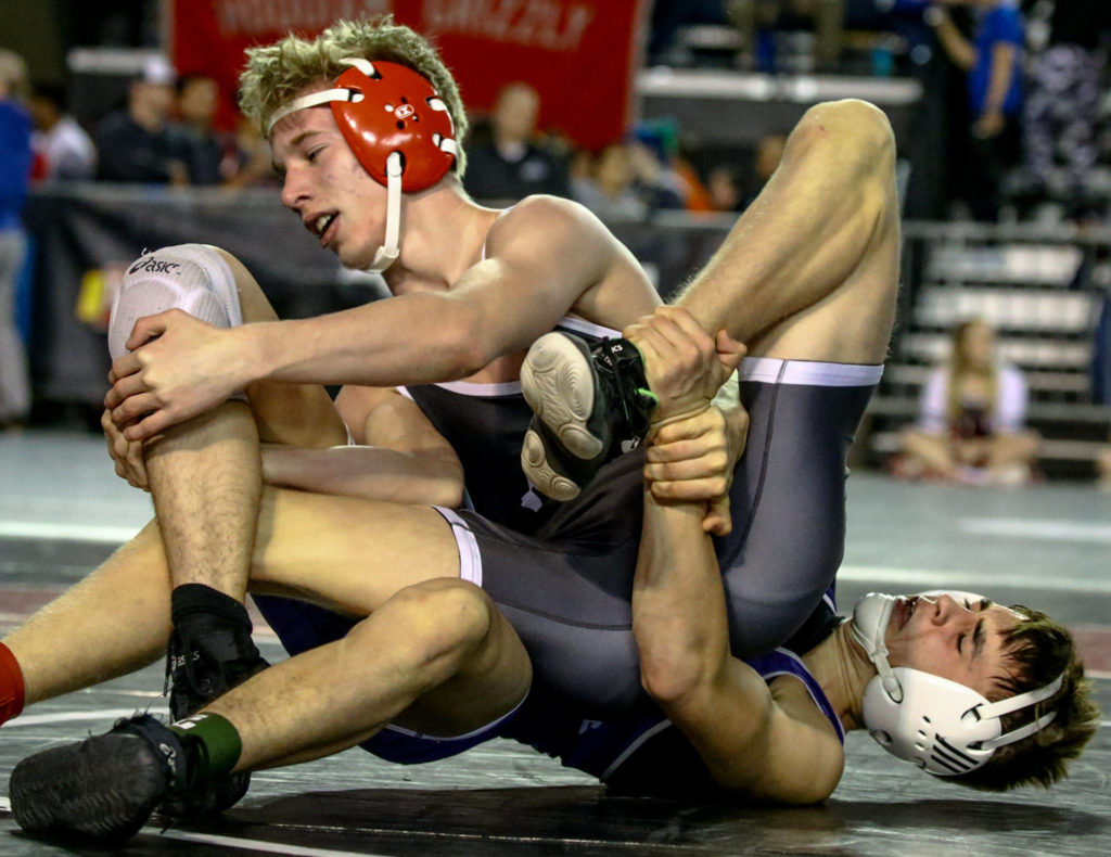 Stanwood’s Keaton Mayernik (top) battles Edmonds-Woodway’s Reece LeCompte during a 3A 120-pound match on Day 1 of Mat Classic XXXII on Friday at the Tacoma Dome. (Kevin Clark / The Herald)
