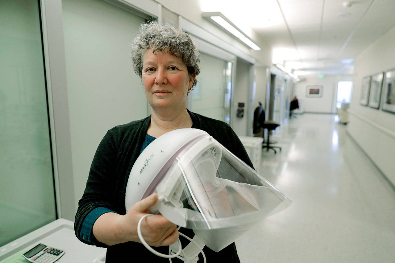 In this photo taken Jan. 23, Robin Addison, a nurse in the Emergency Department and co-lead of the Biocontainment Evaluation and Specialty Treatment Team at Providence Regional Medical Center, poses for a photo with a protective helmet and face shield in Everett. Addison was part of the team that treated the first U.S. patient infected with the new virus from China, who was admitted to the facility on Jan. 20. (AP Photo/Ted S. Warren, file)