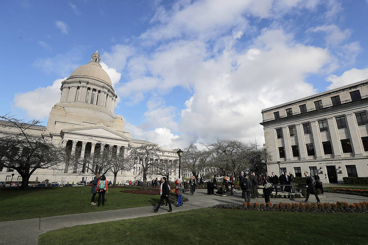 In this Feb. 3 photo, people gather at the sundial in front of the Legislative Building at the Capitol in Olympia. (AP Photo/Ted S. Warren)