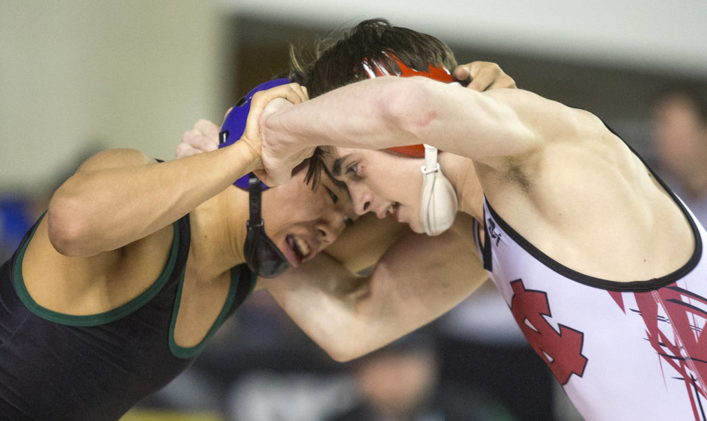 Trying to get the upper hand, Edmonds-Woodway’s Ethan Nguyen (left) battles North Central’s Steven Zaragoza in the 3A 106-pound title match during Mat Classic XXXII on Saturday at the Tacoma Dome. (Andy Bronson / The Herald)
