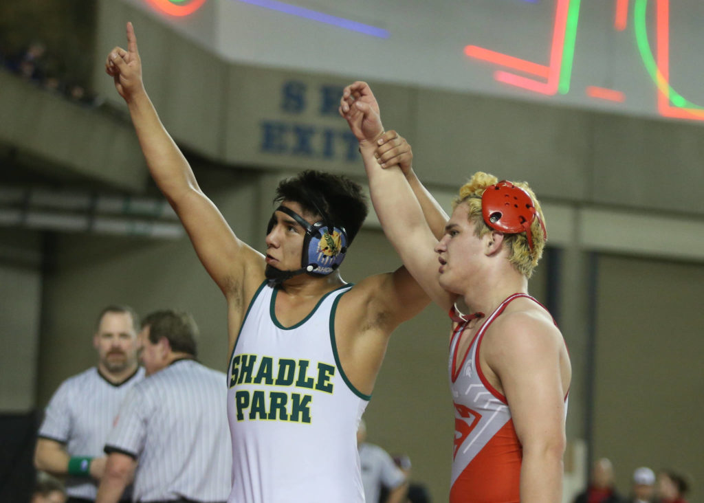 Stanwood’s Riley Van Scoy (right) has his arm raised by Shadle Park’s Juan Escobar after losing in the 3A 170-pound championship match during Mat Classic XXXII on Saturday at the Tacoma Dome. (Andy Bronson / The Herald)
