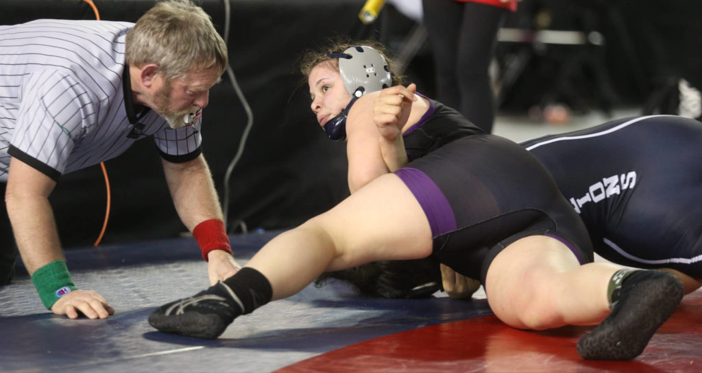 Lake Stevens’ Kiley Hubby (top) looks at the scoreboard as she tries to pin Kennewick’s Alexia Asselin in their girls 170-pound championship match during Mat Classic XXXII on Saturday at the Tacoma Dome. Hubby won by pinfall. (Andy Bronson / The Herald)
