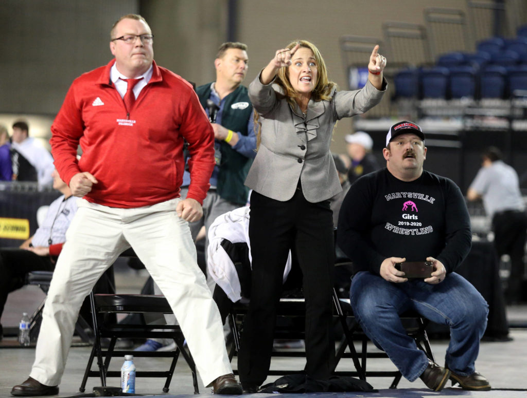 Marysville Pilchuck coach Andrea White (center) reacts after her daughter, Alivia White, pinned Connell’s Rosa Saucedo-Ramirez in the girls 190-pound championship match during Mat Classic XXXII on Saturday at the Tacoma Dome. (Andy Bronson / The Herald)
