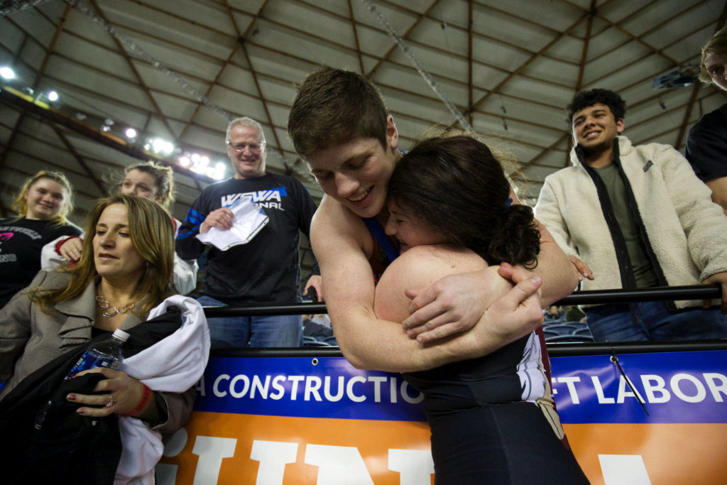Marysville Pilchuck’s Cayden White hugs his sister, Alivia, after she won the girls 190-pound state title at Mat Classic XXXII on Saturday at the Tacoma Dome. Cayden White won the boys 3A state title at 182 pounds earlier in the evening. (Andy Bronson / The Herald)
