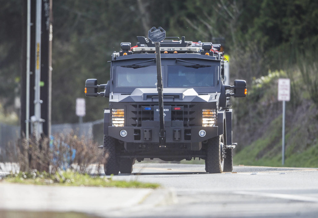 An armored vehicle drives down 52nd Avenue toward a home where a man barricaded himself inside on Sunday near Lynnwood. (Olivia Vanni / The Herald)
