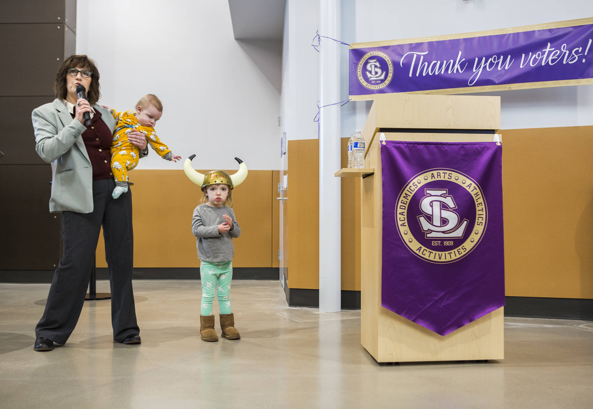 Lake Stevens school board president Mari Taylor holds her grandson Ryker Britton, who reaches for his sister Theta’s Viking helmet on Thursday at Lake Stevens High School. (Olivia Vanni / The Herald)