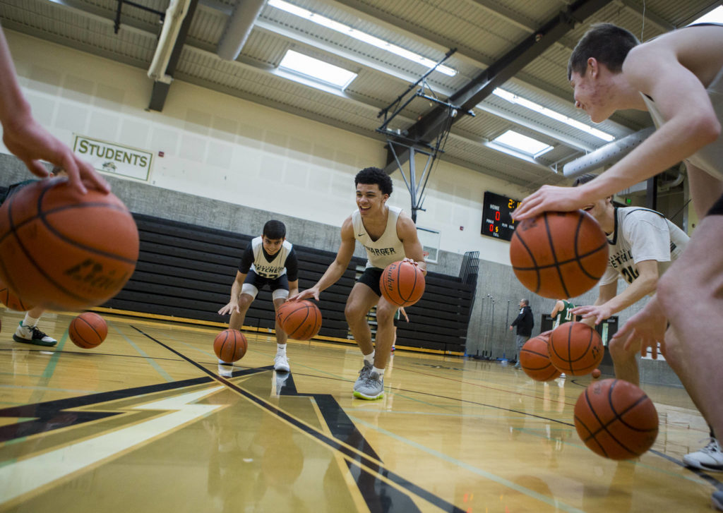 Marysville Getchell junior guard Aiden Verdugo (center) smiles while leading a dribbling drill during practice on Wednesday in Marysville. (Olivia Vanni / The Herald)
