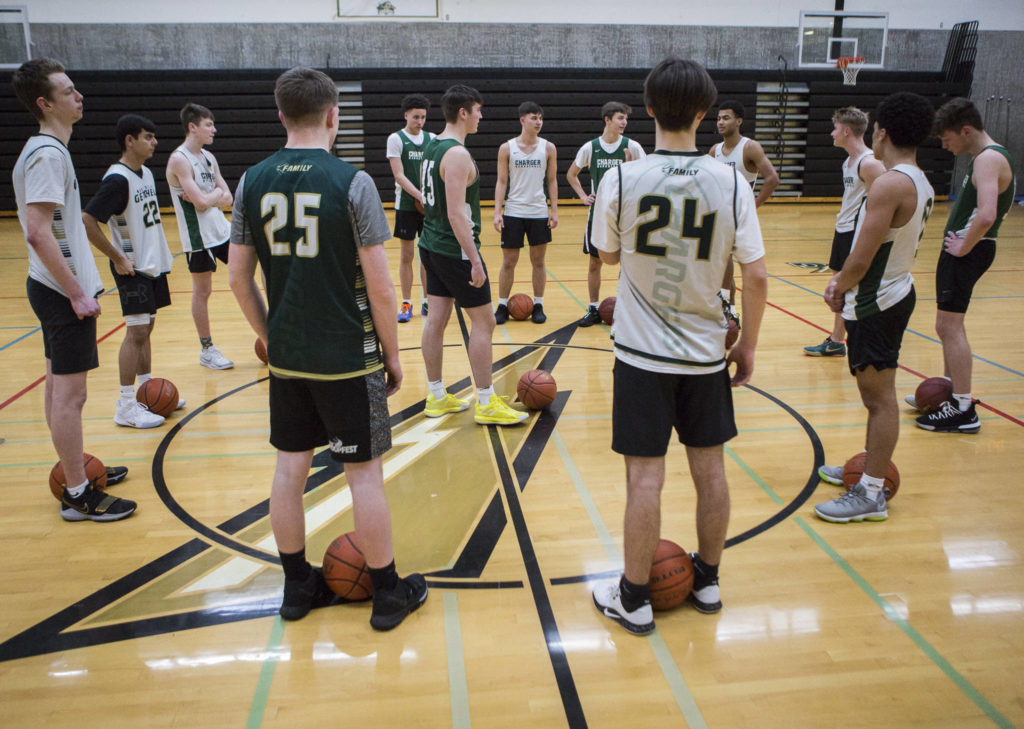 The team gathers at the center of the court before the start of practice on Wednesday, Feb. 26, 2020 in Marysville, Wash. (Olivia Vanni / The Herald)
