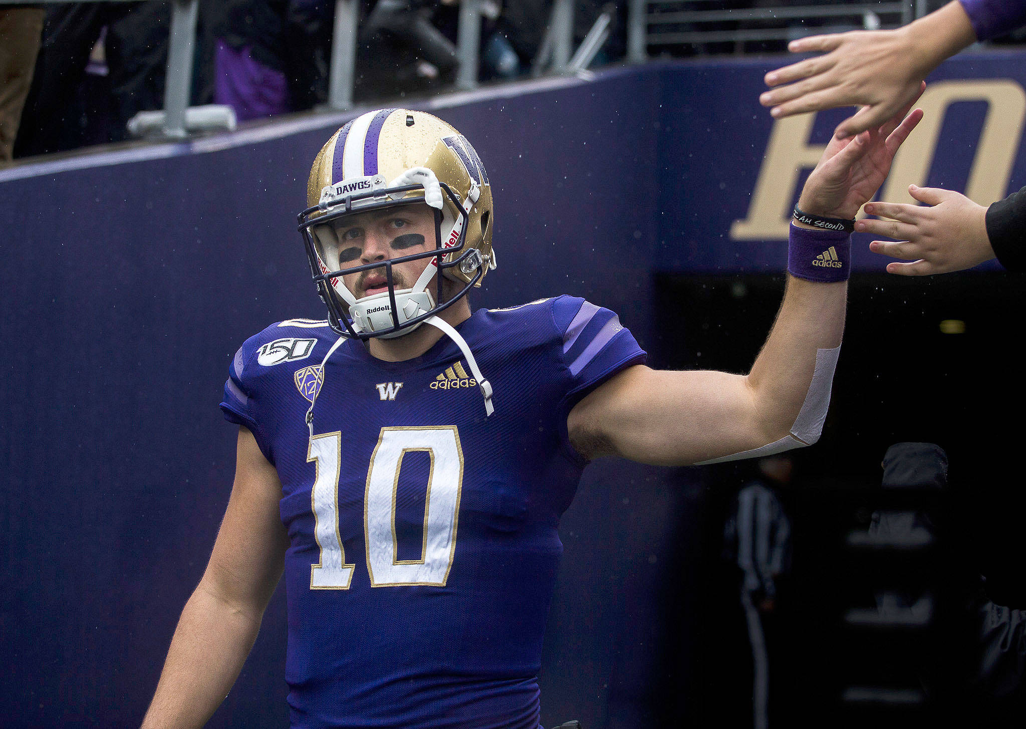Washington quarterback Jacob Eason, a Lake Stevens alum, high-fives fans as he walks out onto the field before a game against Oregon on Oct. 19, 2019, in Seattle. (Olivia Vanni / The Herald)