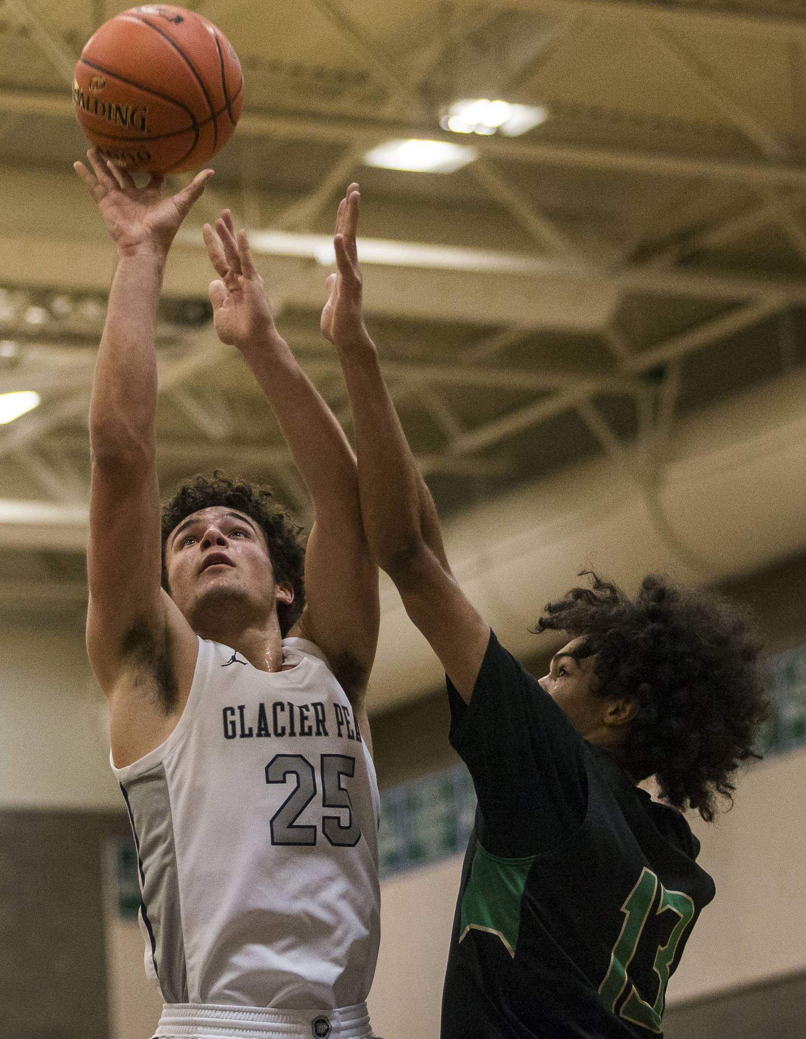 Glacier Peak’s Brayden Quantrille (left) makes a layup while being guarded by Auburn’s Darrell Hester during a 4A state regional game on Saturday at Shorewood High School in Shoreline. (Olivia Vanni / The Herald)