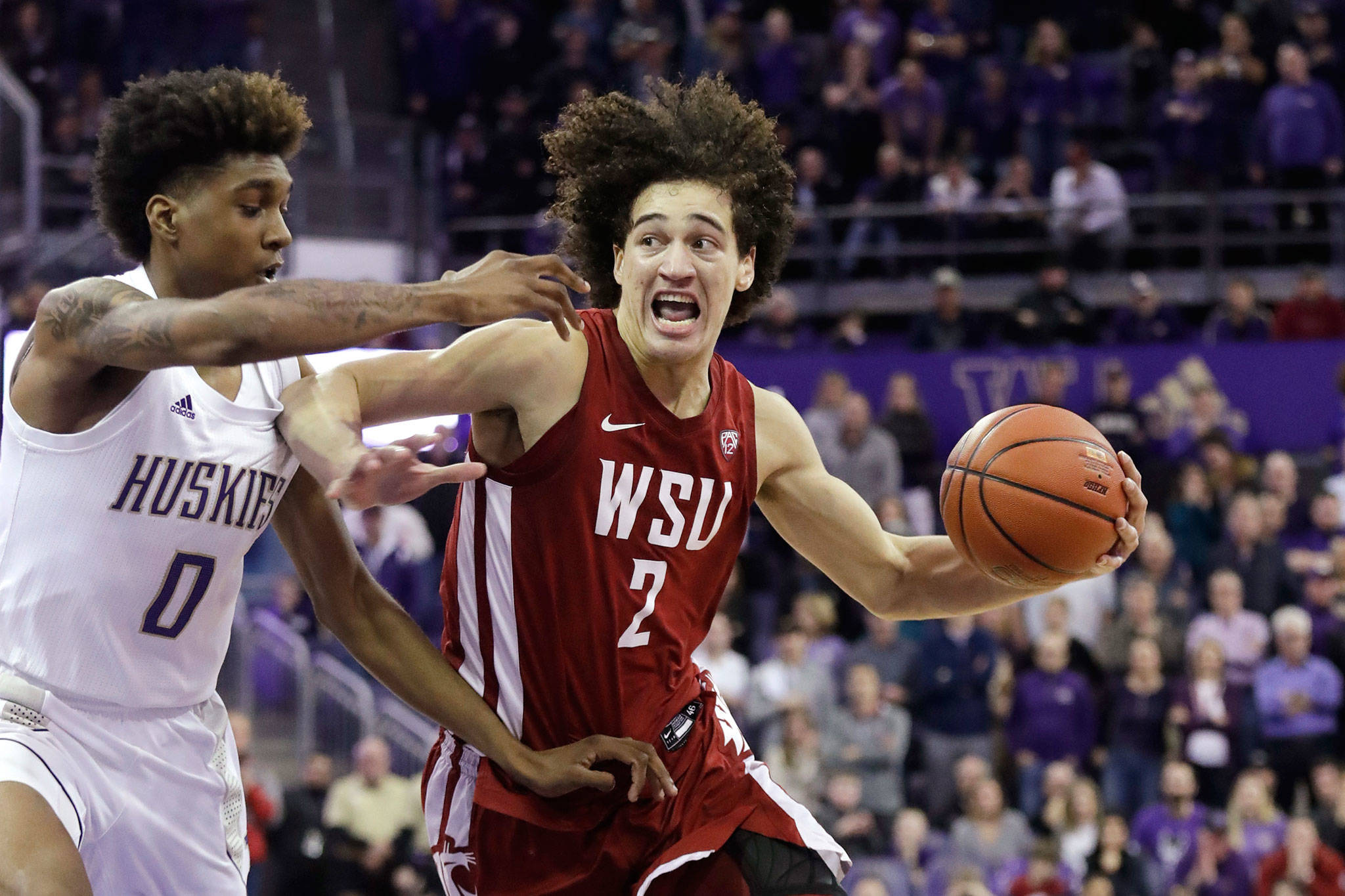 Washington State’s CJ Elleby (2) drives against Washington’s Jaden McDaniels (0) during the second half of a game Friday in Seattle. Washington State won 78-74. (AP Photo/Elaine Thompson)