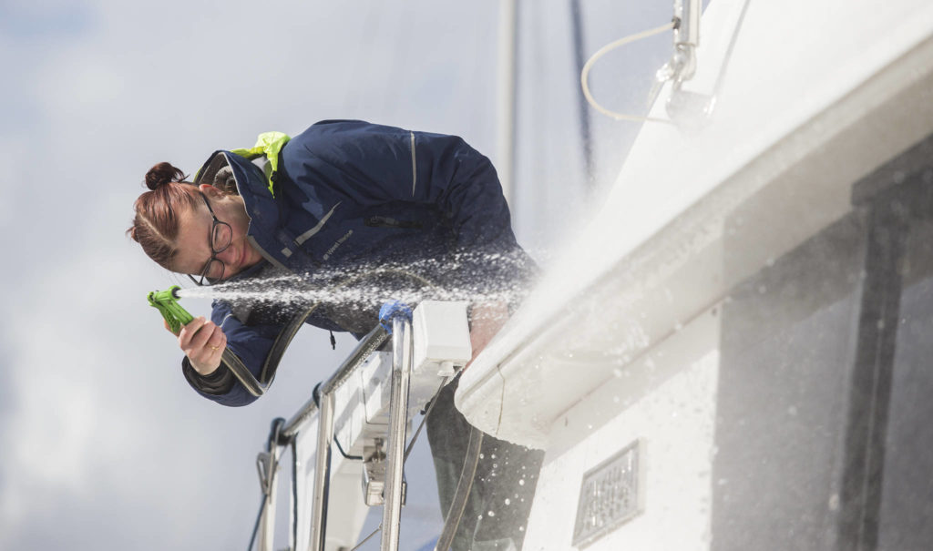 Kelly Jane Heindel cleans a 40-foot yacht at the Everett Marina. (Andy Bronson / The Herald) 
