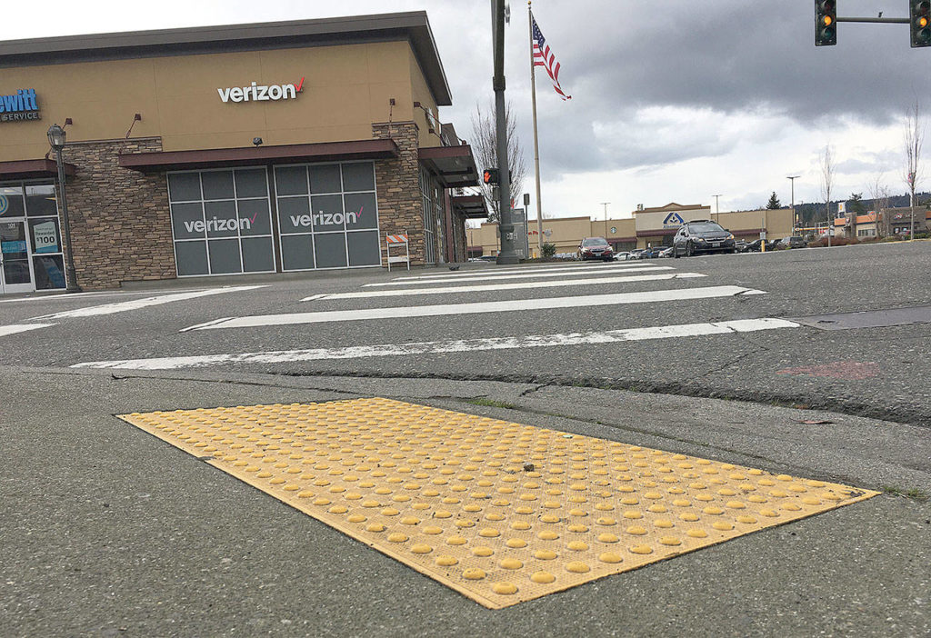 Crosswalks without navigational features like those shown can be nearly impassible for people with disabilities. The bumps on a yellow rectangle, like the ones at the intersection of Third Street and State Avenue, help someone who is blind and their guide animals, and audible crosswalk signals aid as well. (Ben Watanabe / The Herald)
