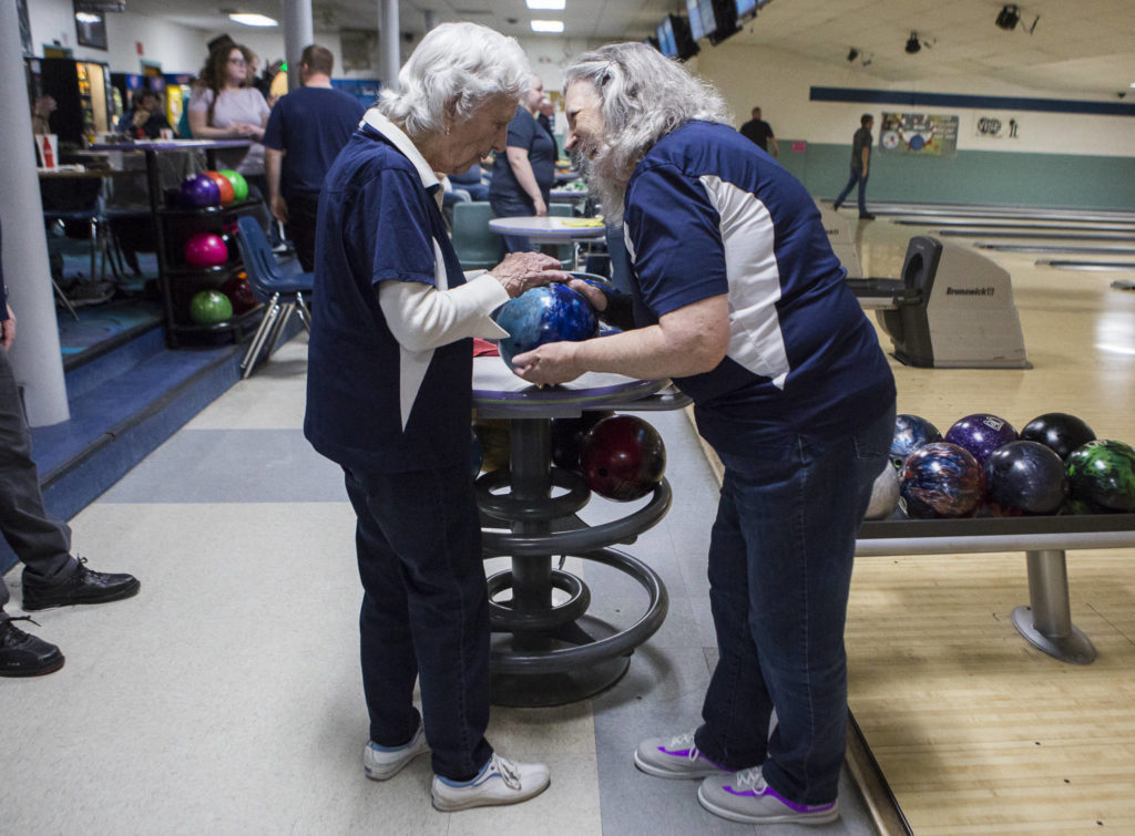 Carol Perry high fives her daughter Kathy Larsen before her turn to bowl during league bowling. (Olivia Vanni / The Herald)
