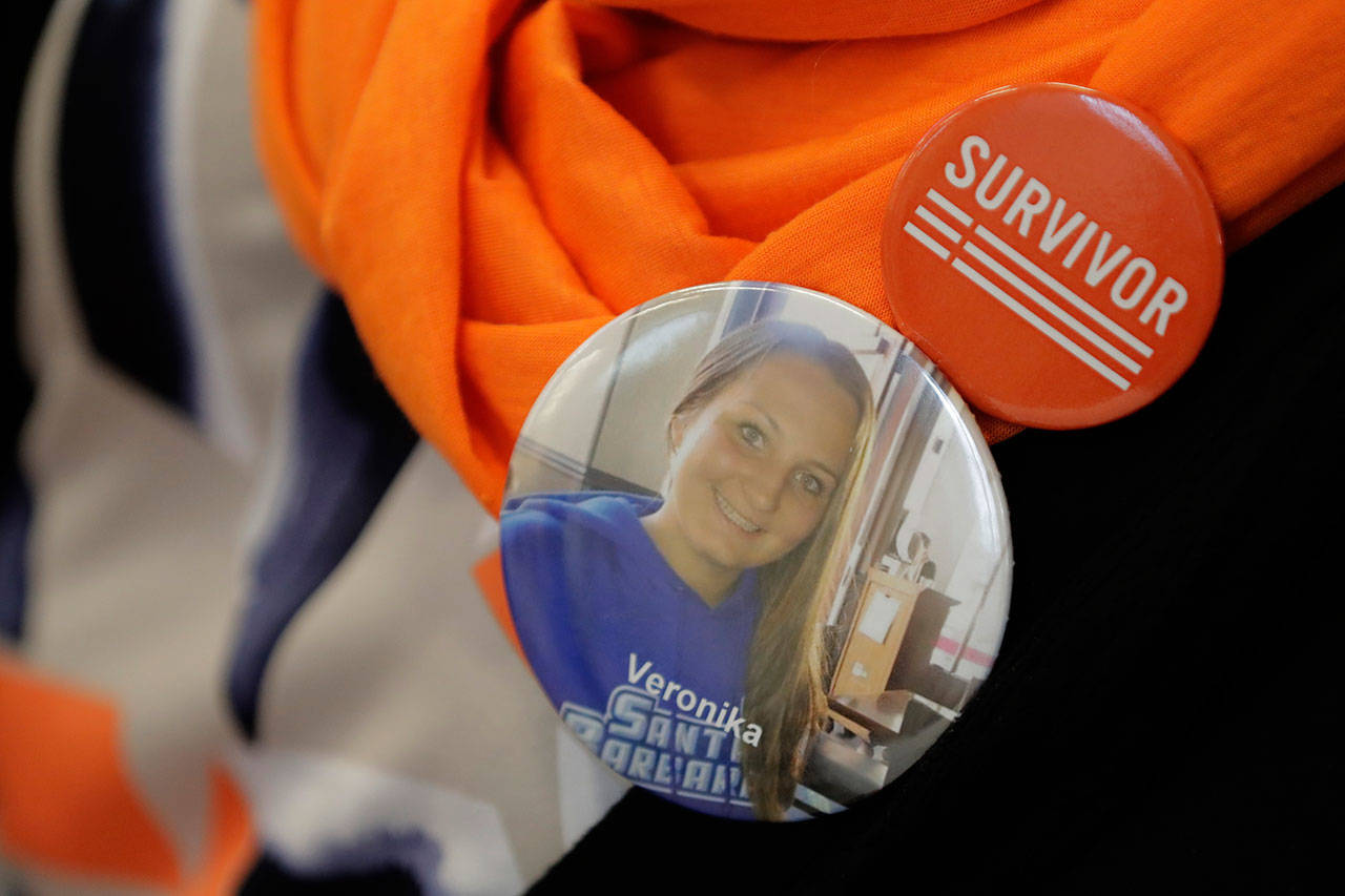 Jane Weiss, a retired Snohomish County teacher, wears a button that reads “Survivor” and one that bears the photo of her niece, Veronika Weiss, who was shot and killed in 2014 in a mass shooting at the University of California Santa Barbara in Isla Vista, Calif.. Weiss was present for testimony, Feb. 25, at the Capitol in Olympia, Wash., on a new bill that would ban high-capacity gun magazines in Washington state. (Ted S. Warren / Associated Press)