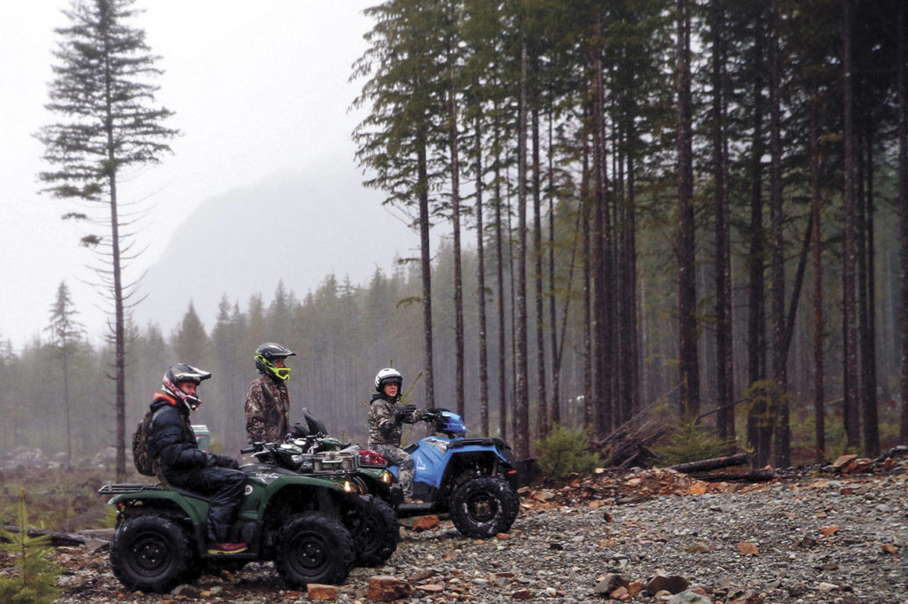 Quintin Henry-Vega, Candace Wiebe and Norma Vasquez take a break during a tour with Chinook ATV Expeditions in the Reiter Foothills State Forest. Trails in the forest typically are about 4 feet wide. (Kevin Clark / The Herald)
