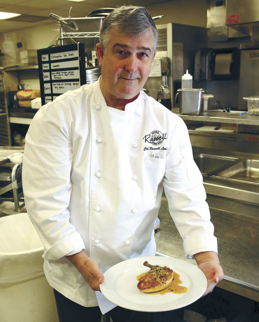 Russell Lowell, chef and owner of Russell’s Restaurant & Loft in Bothell, displays his pan-seared chicken breast with rosemary-garlic sauce. (Kevin Clark / The Herald)
