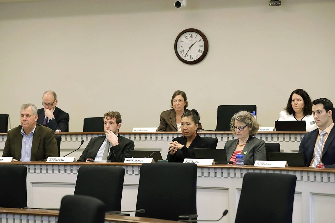 Members of the Washington State House of Representatives’ Environment and Energy Committee, including committee chairman Joe Fitzgibbon (third from left), listen to testimony on Feb. 3 at the Capitol in Olympia during public testimony on a House bill sponsored by Fitzgibbon that seeks to fully reinstate Gov. Jay Inslee’s plan to cap carbon pollution in Washington by giving additional regulatory authority to the state Department of Ecology. (AP Photo/Ted S. Warren)