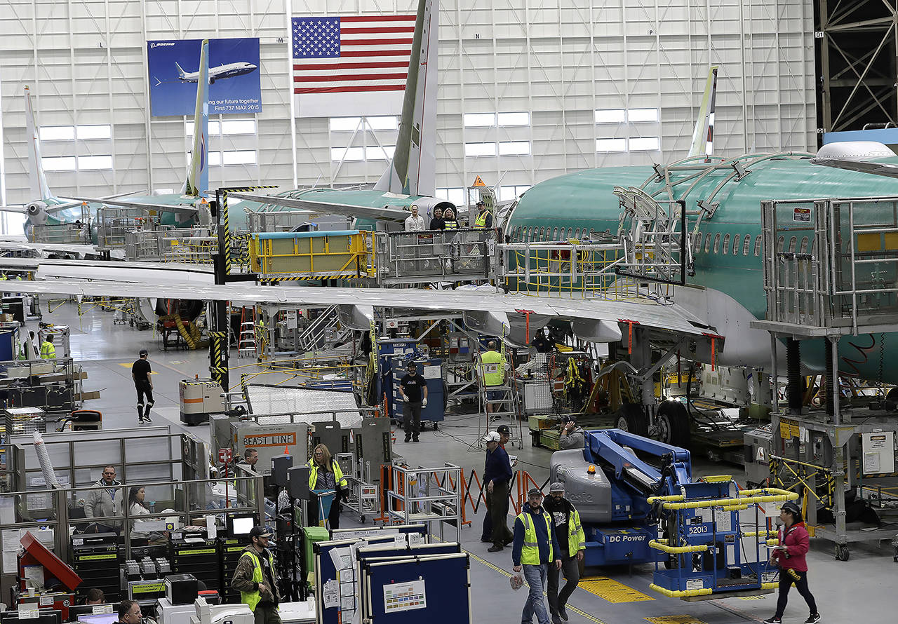 In this 2019 photo, people work on the Boeing 737 Max 8 assembly line in Boeing’s 737 assembly facility in Renton. (AP Photo/Ted S. Warren, File)