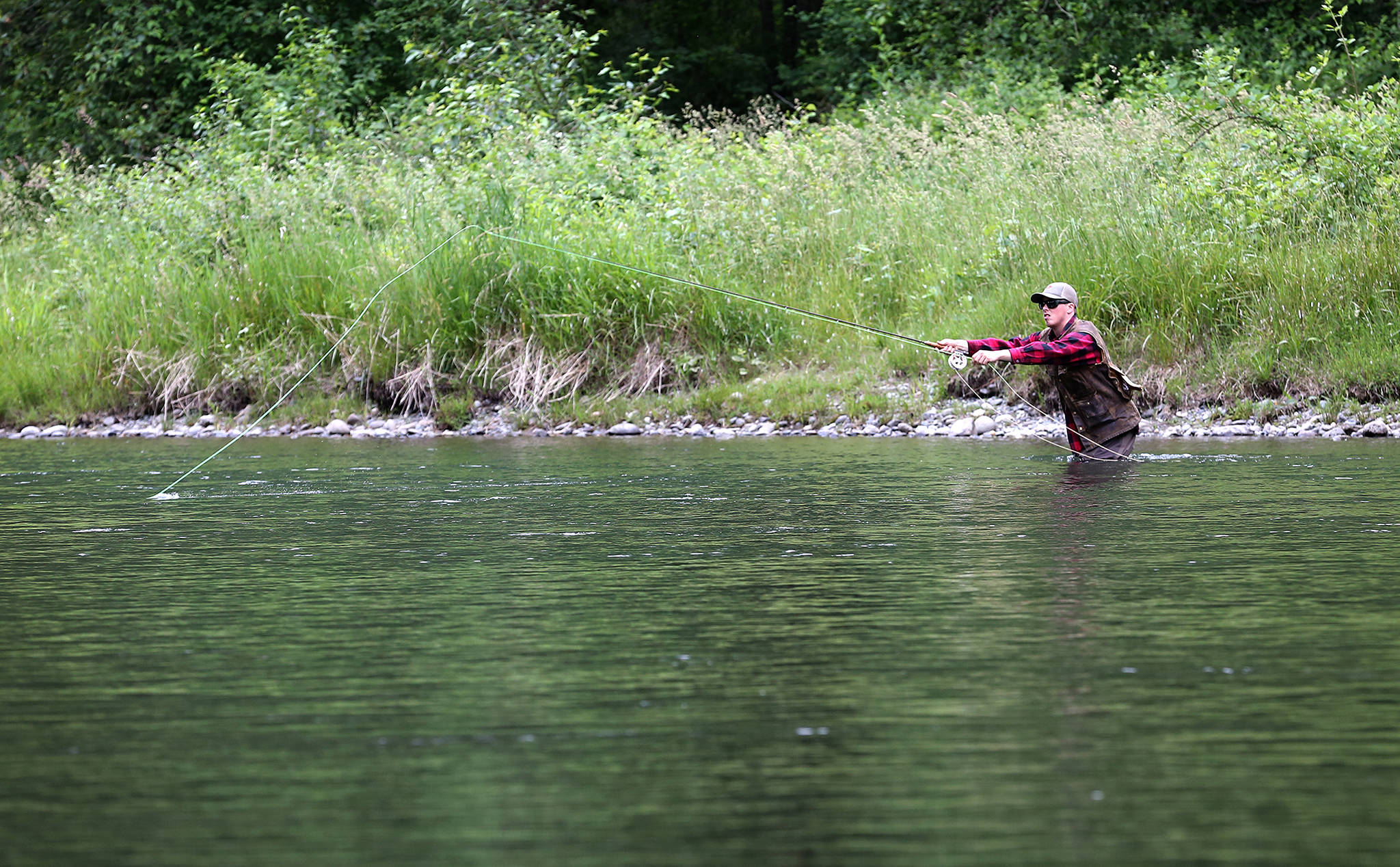 A fisherman wades the waters of Sultan River at Sportsman Park in Sultan, last June. State legislation seeks to limit a specific mining practice on the Sultan and other rivers and streams in the county. (Kevin Clark / Herald file photo)