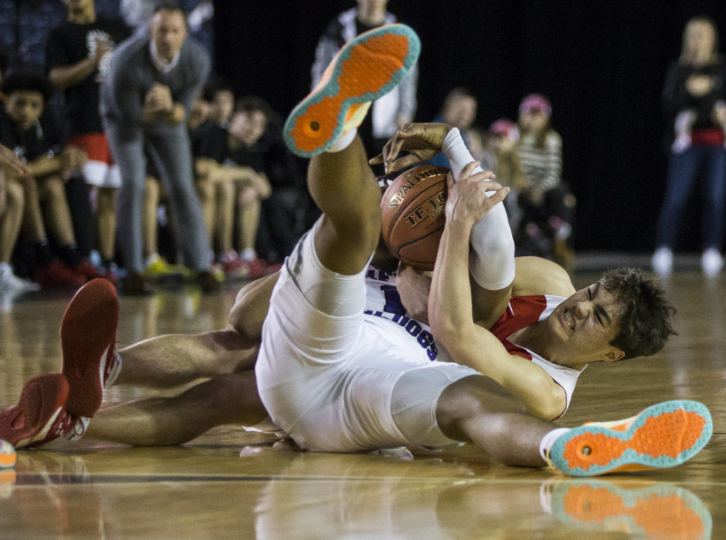 Marysville Pilchuck’s Brady Phelps fights Garfield’s Kendall Munson for the ball during a 3A boys Hardwood Classic quarterfinal on Thursday in Tacoma. (Olivia Vanni / The Herald)
