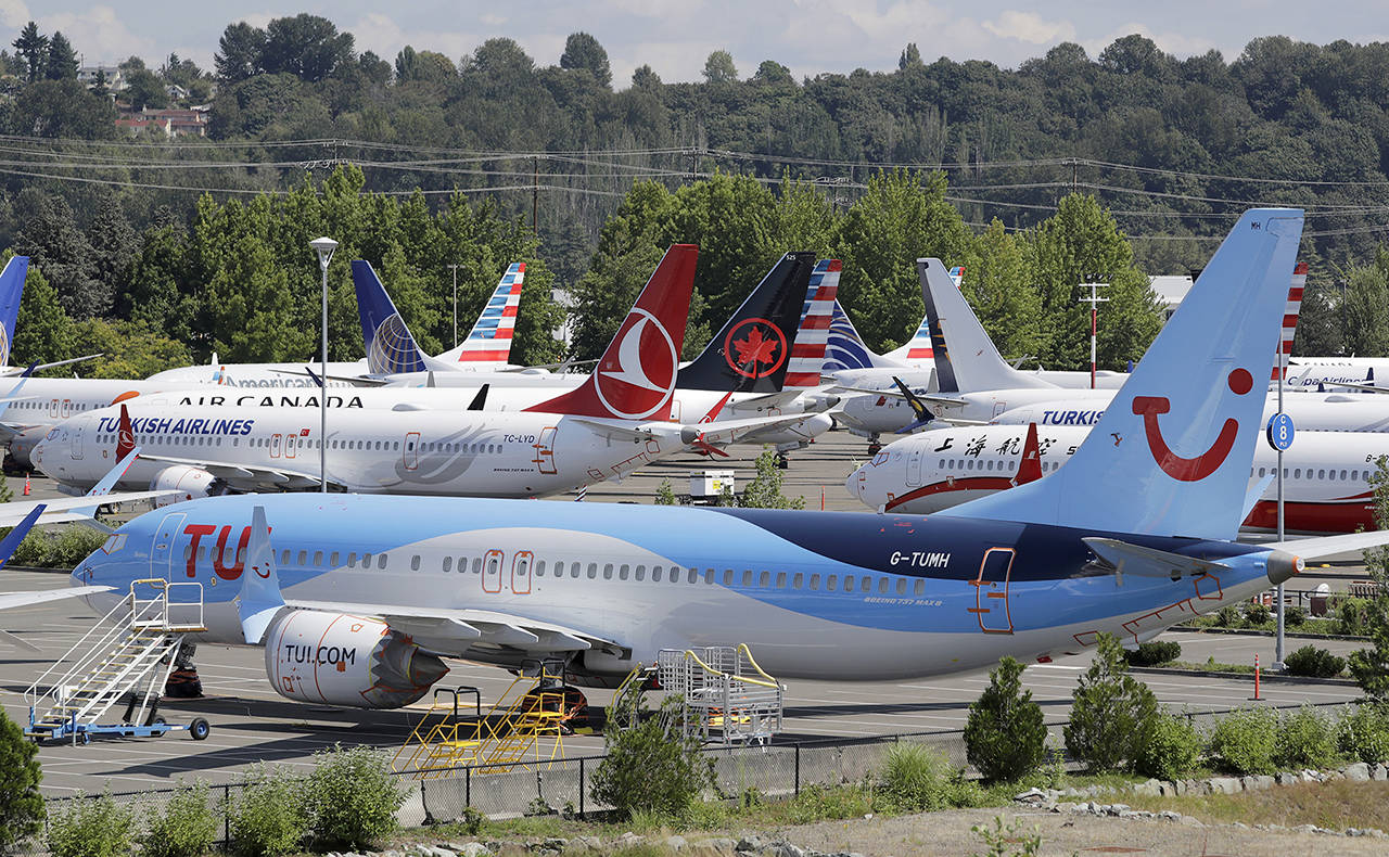 This 2019 photo shows dozens of grounded Boeing 737 Max airplanes crowd a parking area adjacent to Boeing Field in Seattle. (AP Photo/Elaine Thompson, File)