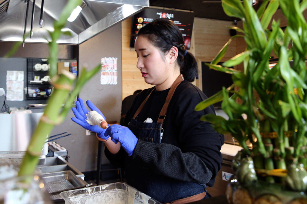 Seoul Hotdog co-owner Aram Han makes a Korean corn dog at the new shop in Lynnwood. (Kevin Clark / The Herald)
