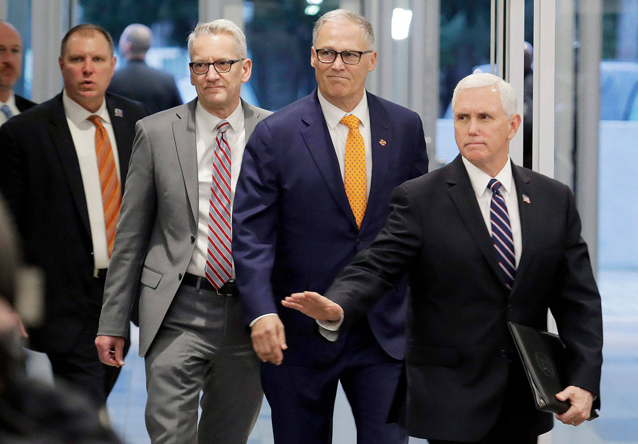 Vice President Mike Pence (right) arrives with Washington Gov. Jay Inslee (second from right) and John Wiesman, Washington state Secretary of Health (second from left), for a news conference Thursday at Camp Murray. (AP Photo/Ted S. Warren)